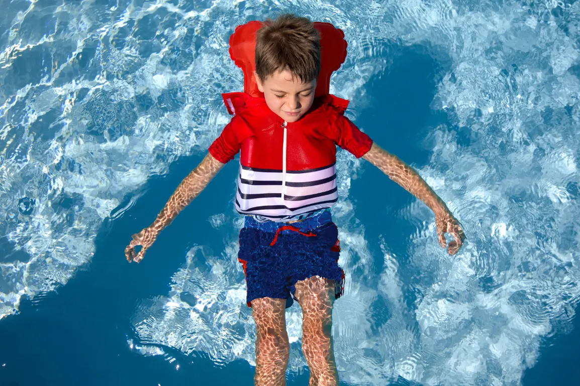 Floatee: Urlaub am Strand – aber sicher - Junge im Wasser mit Sicherheits-T-Shirt